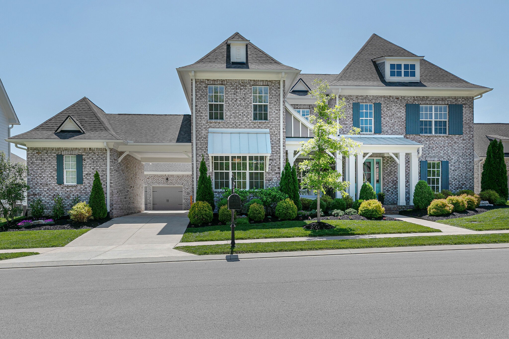 a front view of a house with a yard and plants