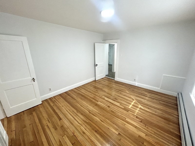 119 Bailey Road, Unit 1 Somerville, MA 02145 - Photo 12 of 25 a view of a room with wooden floor and closet