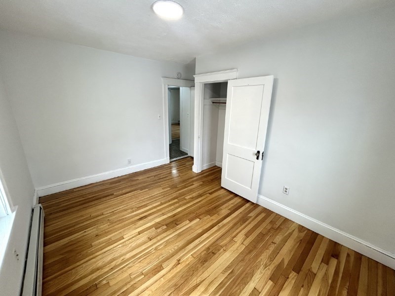 119 Bailey Road, Unit 1 Somerville, MA 02145 - Photo 16 of 25 a view of an empty room with wooden floor