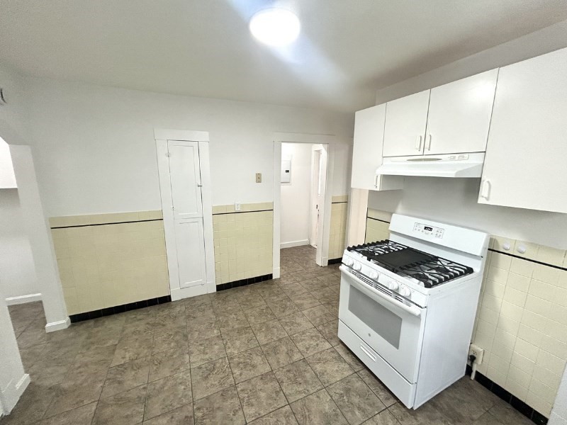 119 Bailey Road, Unit 1 Somerville, MA 02145 - Photo 19 of 25 a kitchen with white cabinets and white appliances