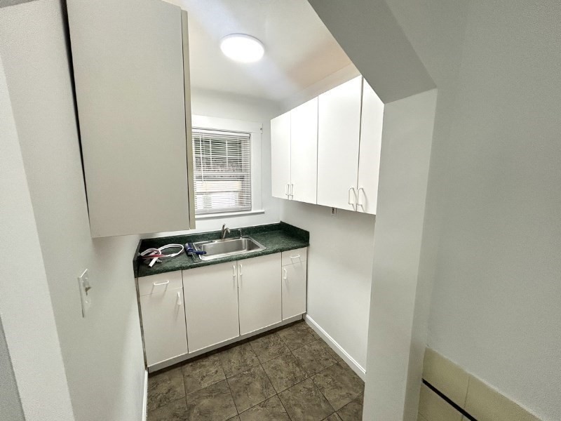 119 Bailey Road, Unit 1 Somerville, MA 02145 - Photo 21 of 25 a room with granite countertop a sink and a stove