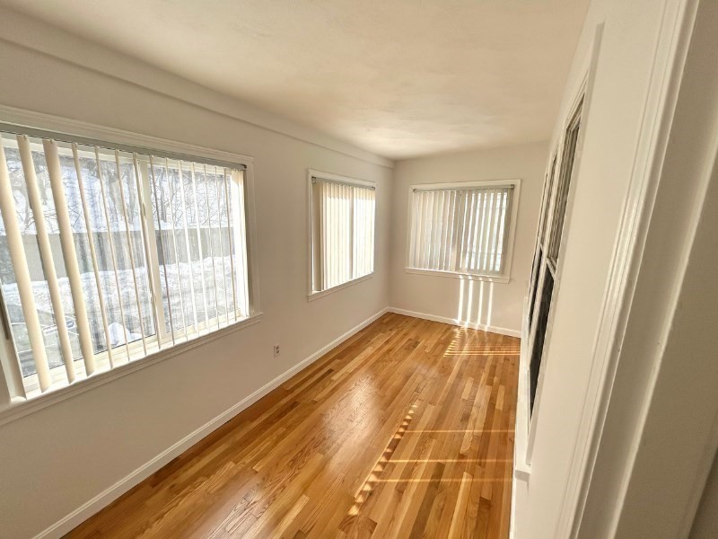 119 Bailey Road, Unit 1 Somerville, MA 02145 - Photo 24 of 25 a view of an empty room with wooden floor and a window
