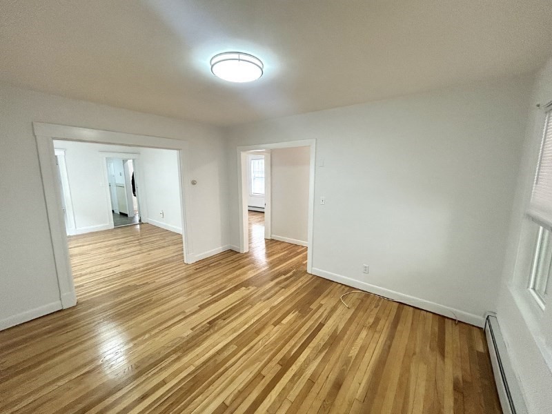 119 Bailey Road, Unit 1 Somerville, MA 02145 - Photo 4 of 25 a view of an empty room and wooden floor