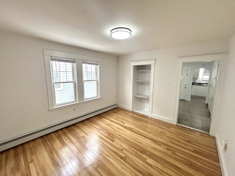 119 Bailey Road, Unit 1 Somerville, MA 02145 - Photo 5 of 25 wooden floor in an empty room with a window