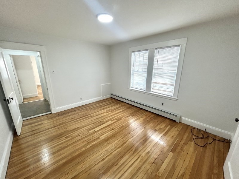 119 Bailey Road, Unit 1 Somerville, MA 02145 - Photo 9 of 25 a view of a room with wooden floor and window