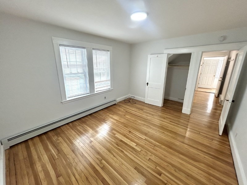 119 Bailey Road, Unit 1 Somerville, MA 02145 - Photo 10 of 25 an empty room with wooden floor and windows