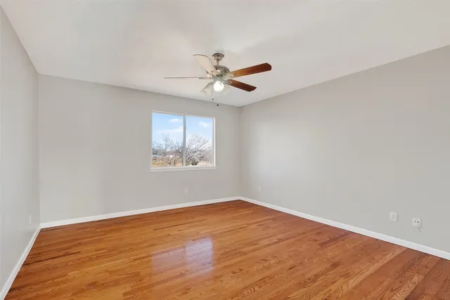 a view of a big room with wooden floor and windows