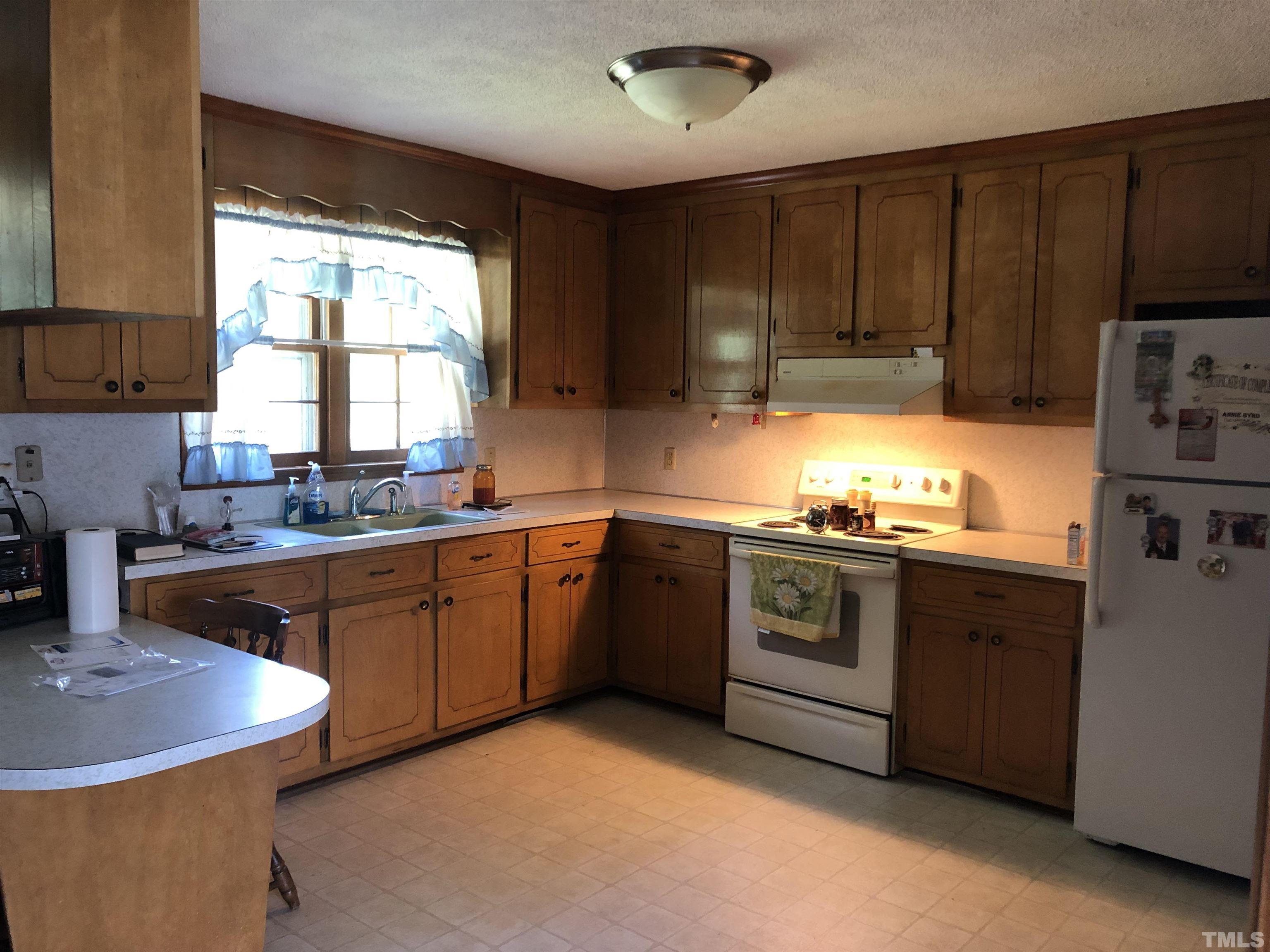 927 Junction Road Durham, NC 27704 - Photo 2 of 22 a kitchen with stainless steel appliances granite countertop a sink a stove a refrigerator cabinets and a window