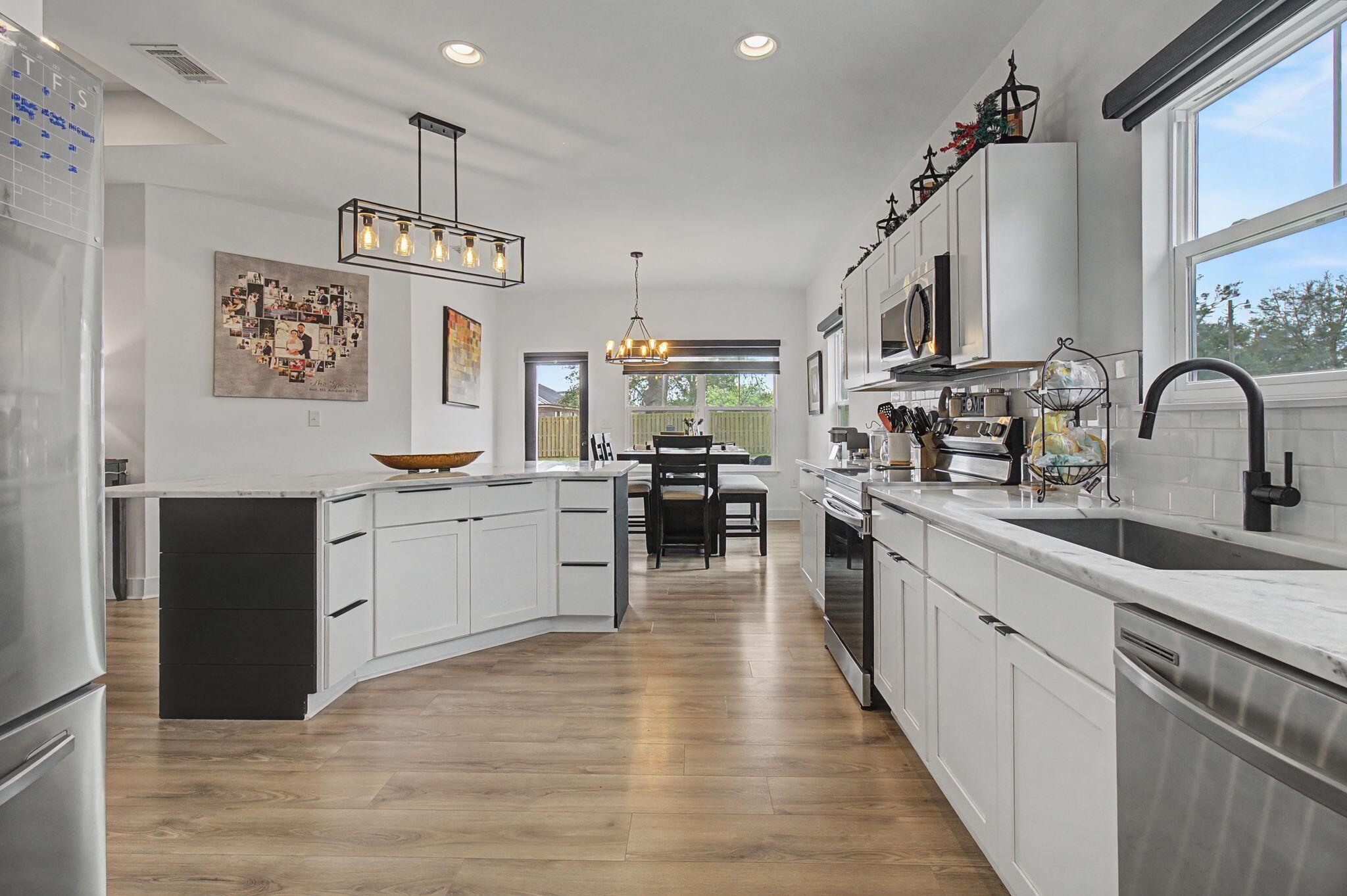 197 West 1st Avenue Crestview, FL 32536 - Photo 12 of 32 a kitchen with stainless steel appliances granite countertop a sink cabinets a stove and a refrigerator