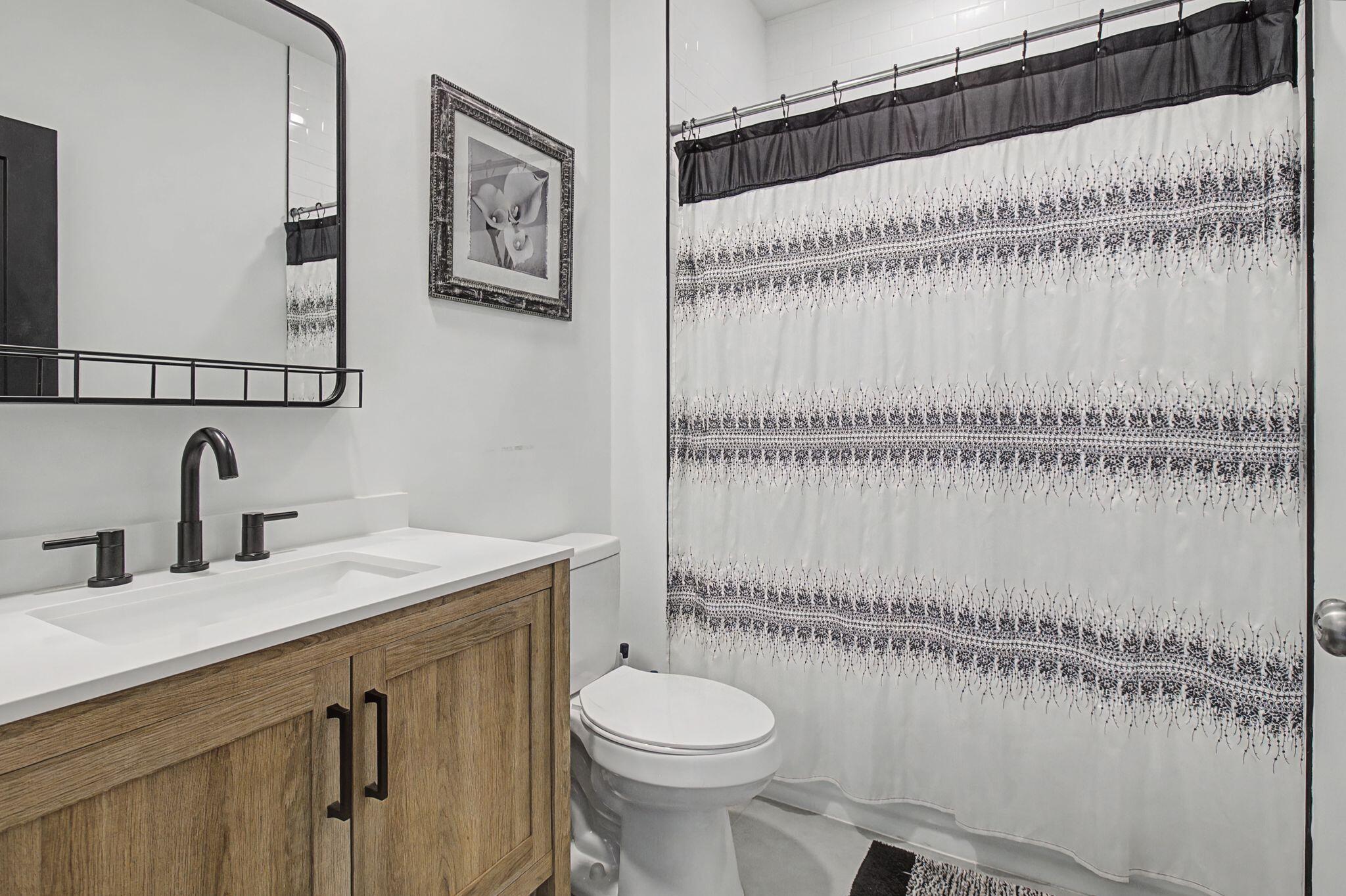 197 West 1st Avenue Crestview, FL 32536 - Photo 22 of 32 a bathroom with a granite countertop sink mirror vanity and toilet