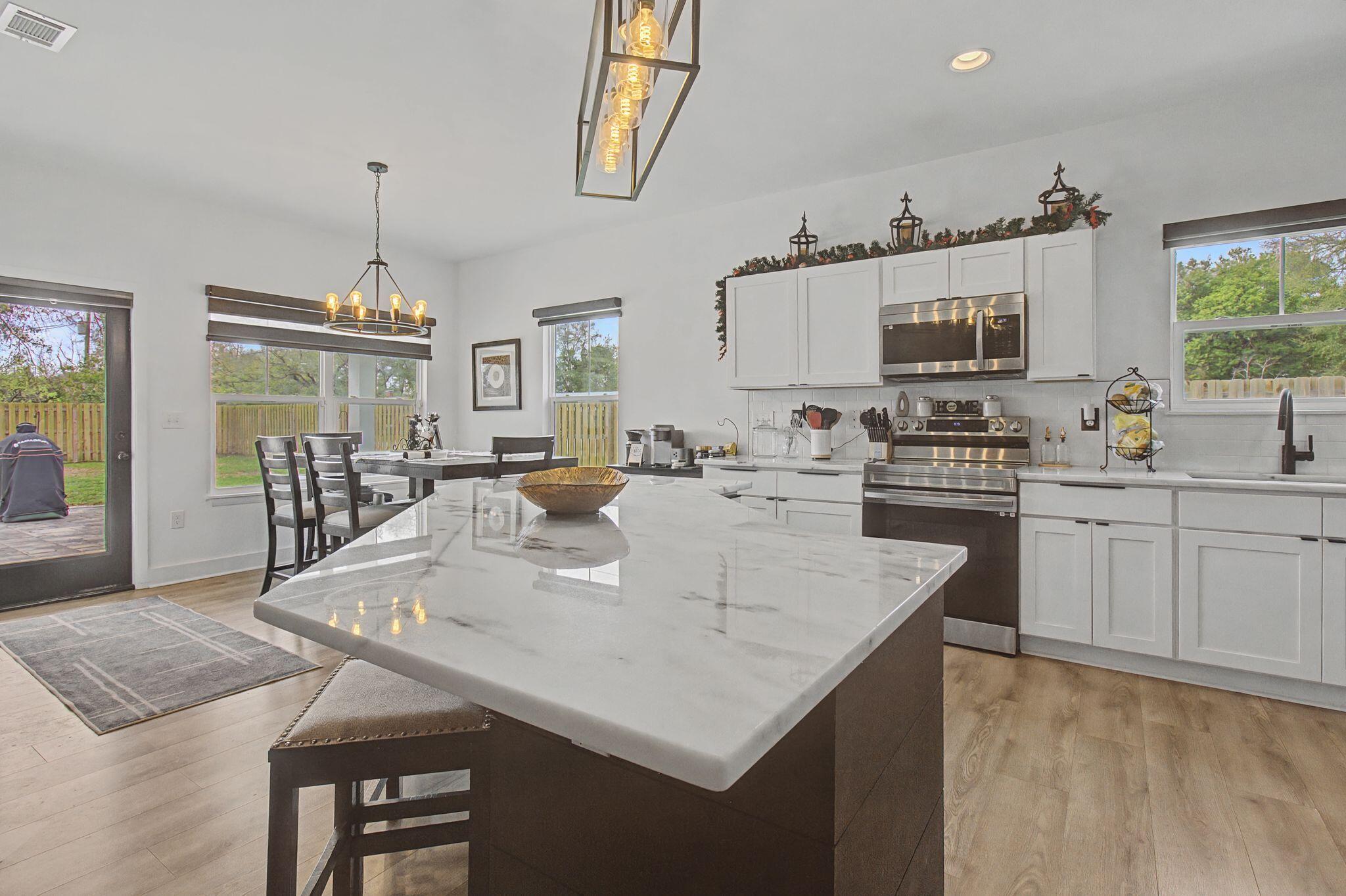 197 West 1st Avenue Crestview, FL 32536 - Photo 8 of 32 a large kitchen with a table chairs and a refrigerator