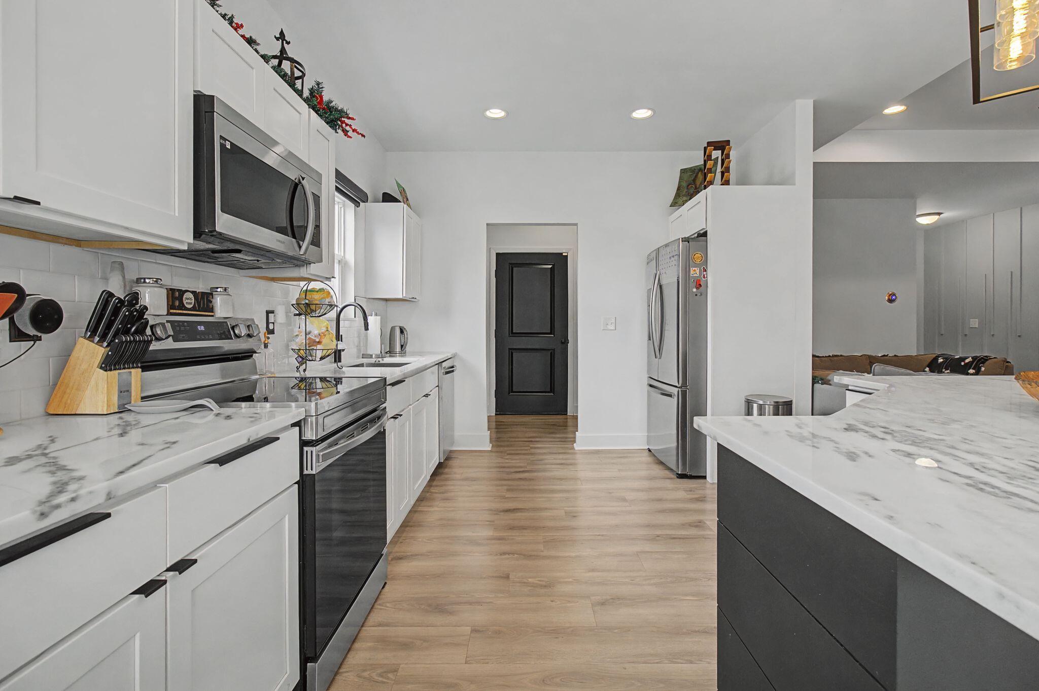 197 West 1st Avenue Crestview, FL 32536 - Photo 10 of 32 a large kitchen with stainless steel appliances granite countertop a lot of counter space and wooden floor