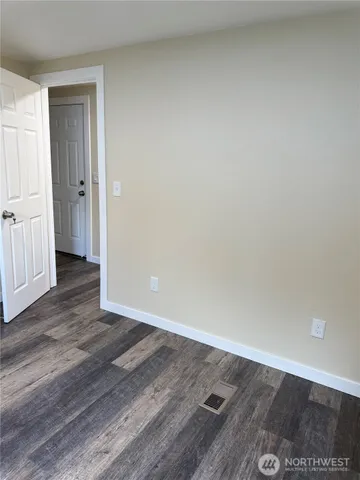 a view of an empty room and wooden floor