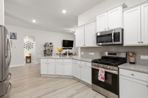 a kitchen with stainless steel appliances granite countertop a stove top oven a sink dishwasher and a microwave oven with cabinets