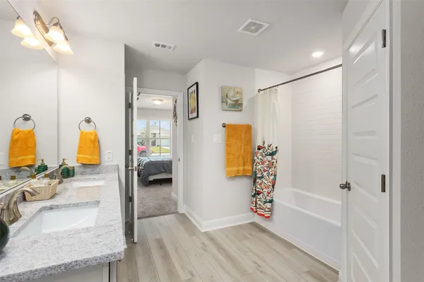a spacious bathroom with a granite countertop sink a mirror and shower