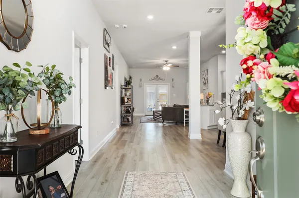 a view of a hallway with furniture and a potted plant