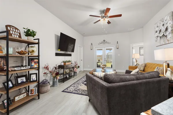 a living room with furniture a window and a flat screen tv