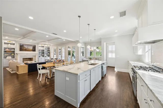 a large kitchen with kitchen island a stove a table and chairs
