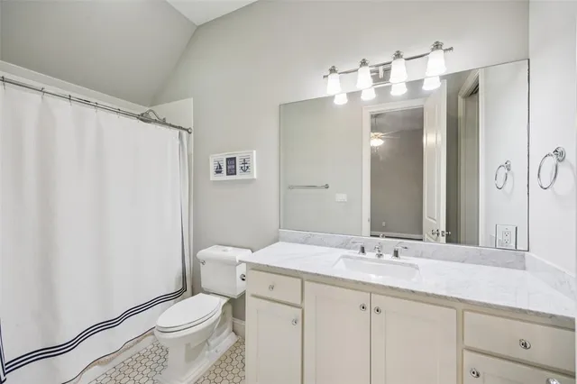 a bathroom with a sink a toilet and large mirror