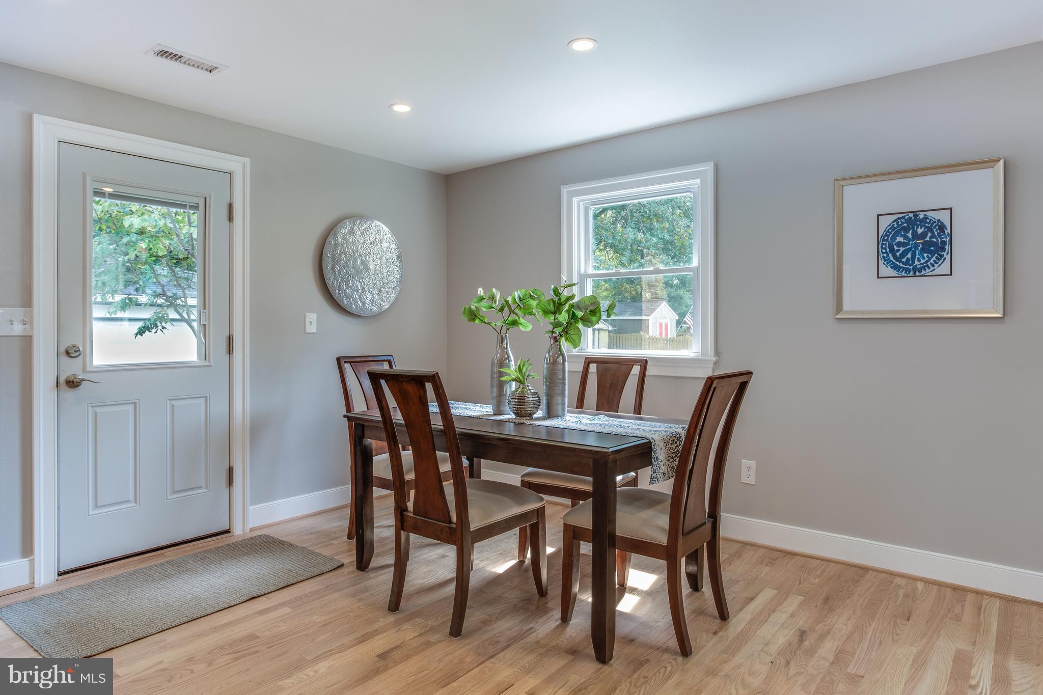 7017 Quander Road Alexandria, VA 22307 - Photo 16 of 30 a dining room with furniture a potted plant and wooden floor