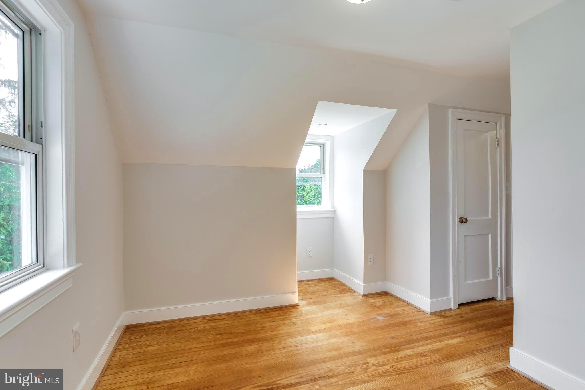 7017 Quander Road Alexandria, VA 22307 - Photo 22 of 30 a view of an empty room with wooden floor and a window