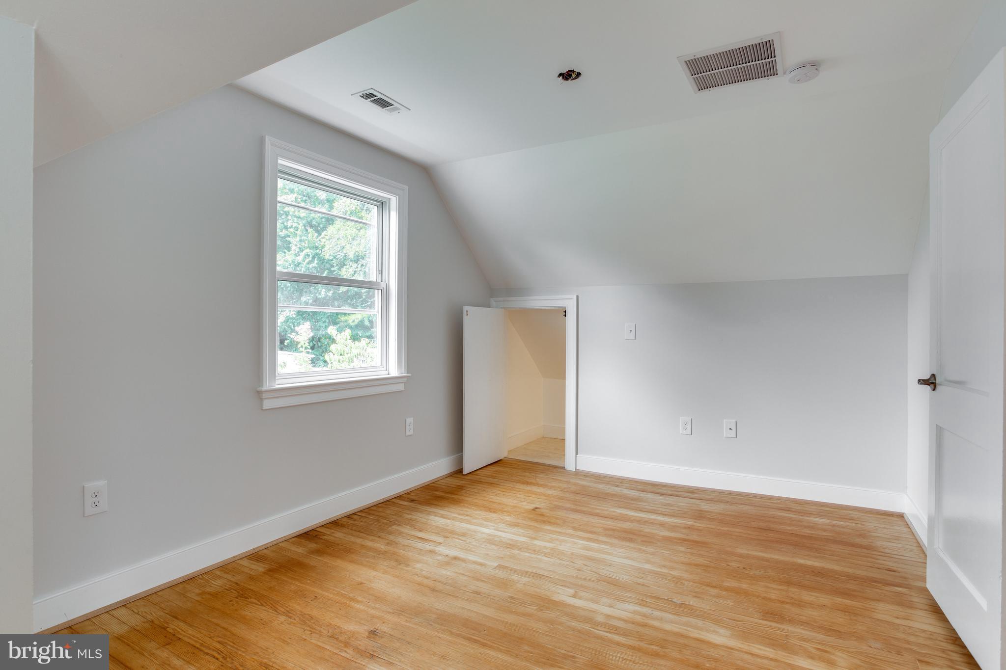 7017 Quander Road Alexandria, VA 22307 - Photo 25 of 30 a view of an empty room with wooden floor and a window