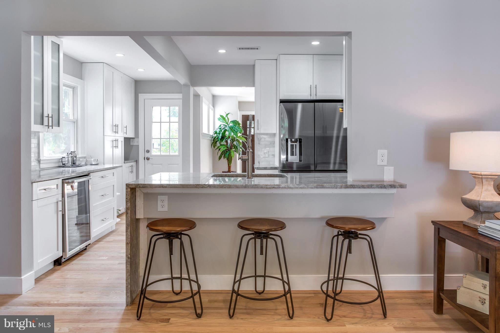 7017 Quander Road Alexandria, VA 22307 - Photo 4 of 30 a kitchen with stainless steel appliances a dining table chairs and chandelier