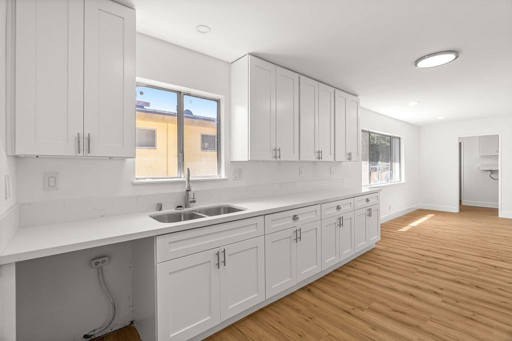a kitchen with sink cabinets and wooden floor