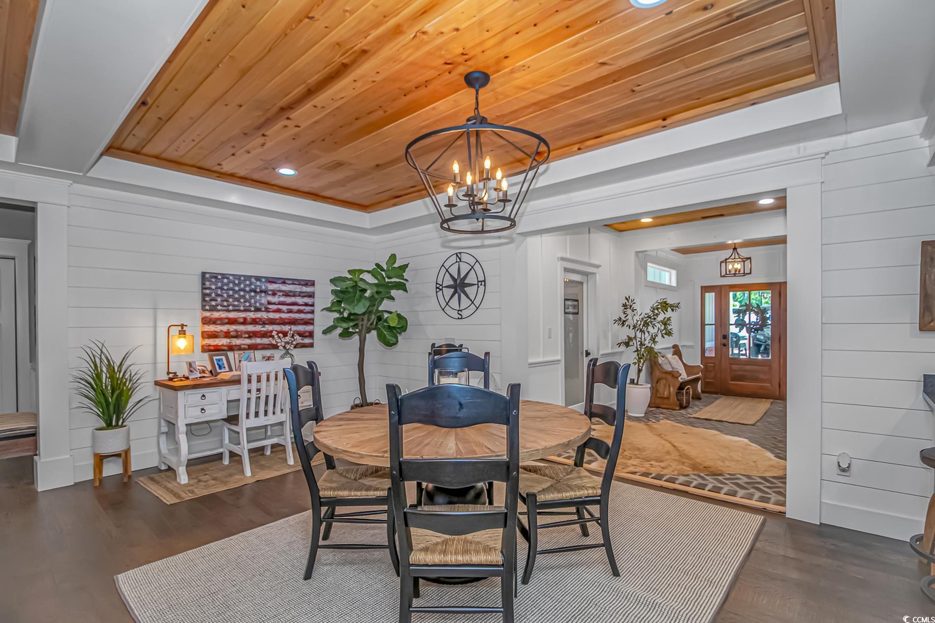 15810 County Line Road Andrews, SC 29510 - Photo 12 of 35 Dining area with a chandelier, dark wood finished floors, wooden ceiling, a raised ceiling, and wood walls