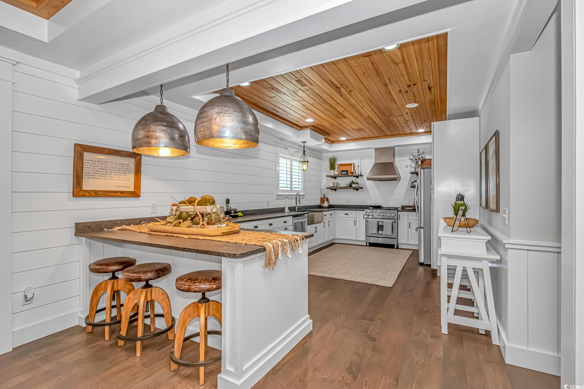 15810 County Line Road Andrews, SC 29510 - Photo 13 of 35 Kitchen with wooden ceiling, a peninsula, appliances with stainless steel finishes, dark wood-style floors, and ventilation hood