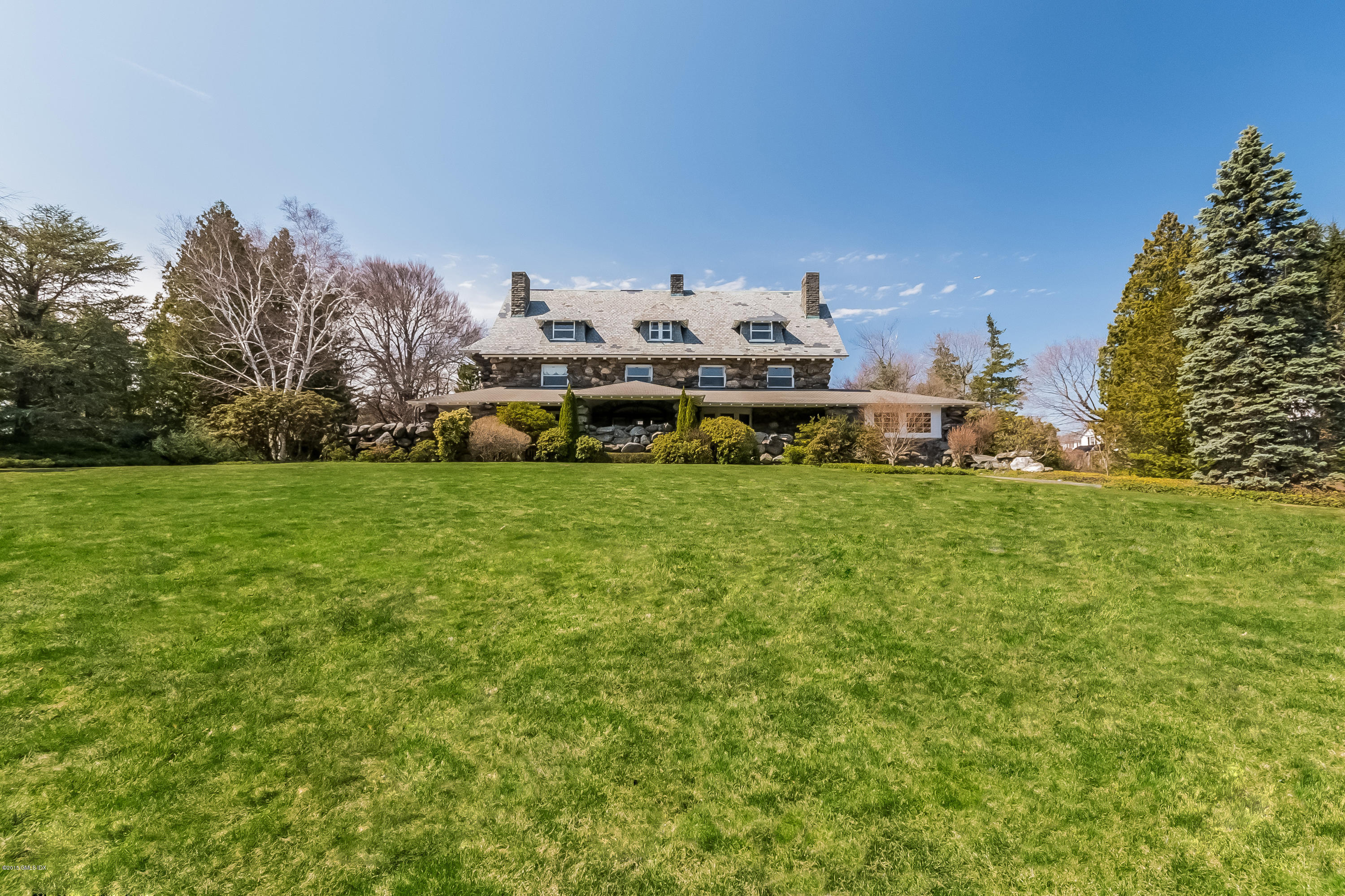 a view of a house with a big yard and a large tree