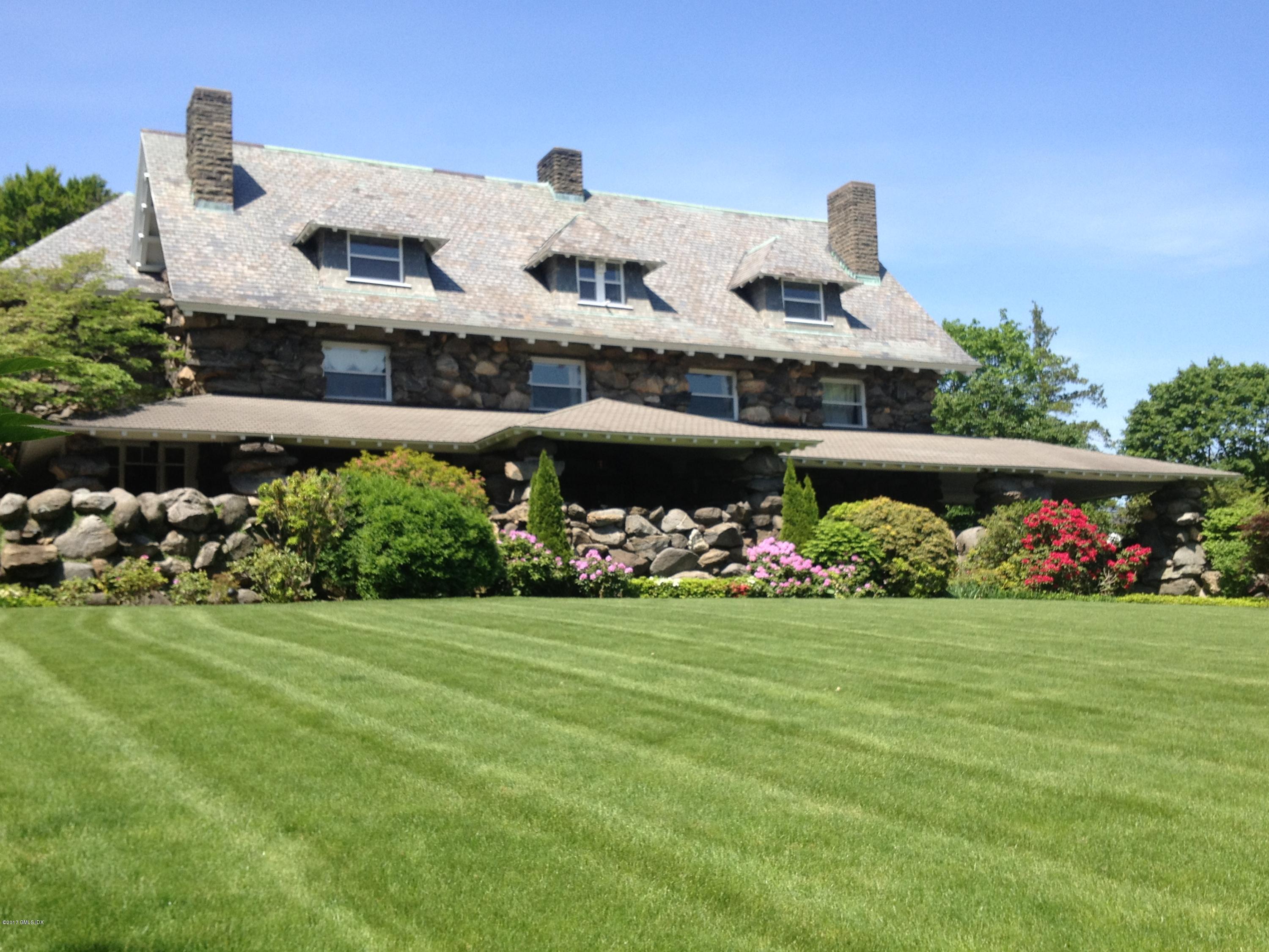 432 Field Point Road Greenwich, CT 06830 - Photo 2 of 25 a front view of a house with a yard and garage