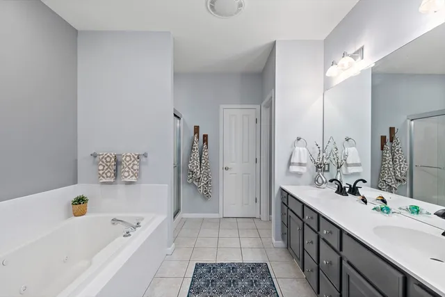 a bathroom with a tub a sink and mirror