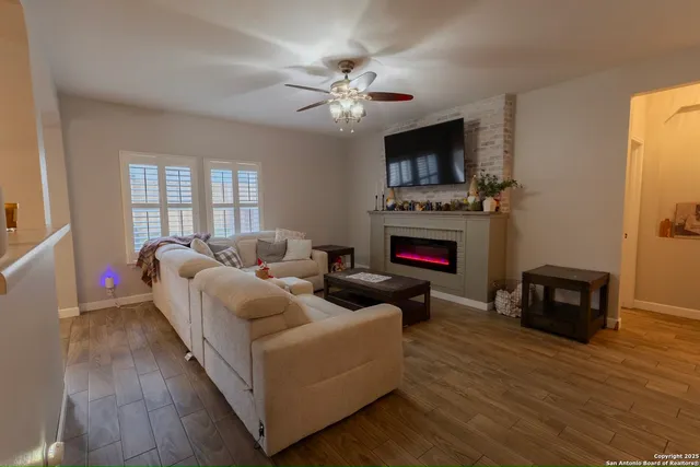 a living room with furniture a fireplace and a flat screen tv