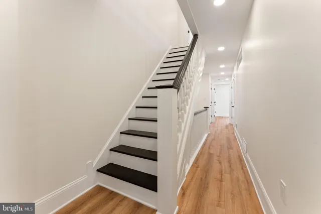 a view of a hallway with wooden floor and staircase