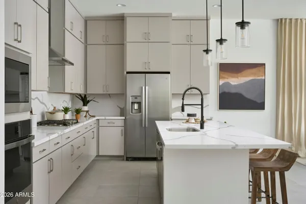 a kitchen with stainless steel appliances granite countertop a sink a stove a refrigerator and island with wooden floor