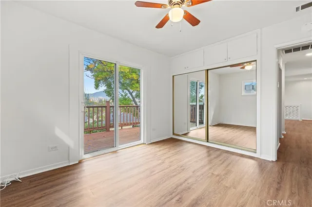 an empty room with wooden floor and sliding door
