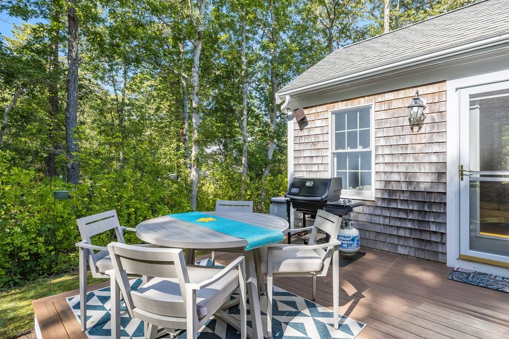 3 Stephen Hopkins Road Harwich, MA 02645 - Photo 38 of 42 a backyard of a house with table and chairs