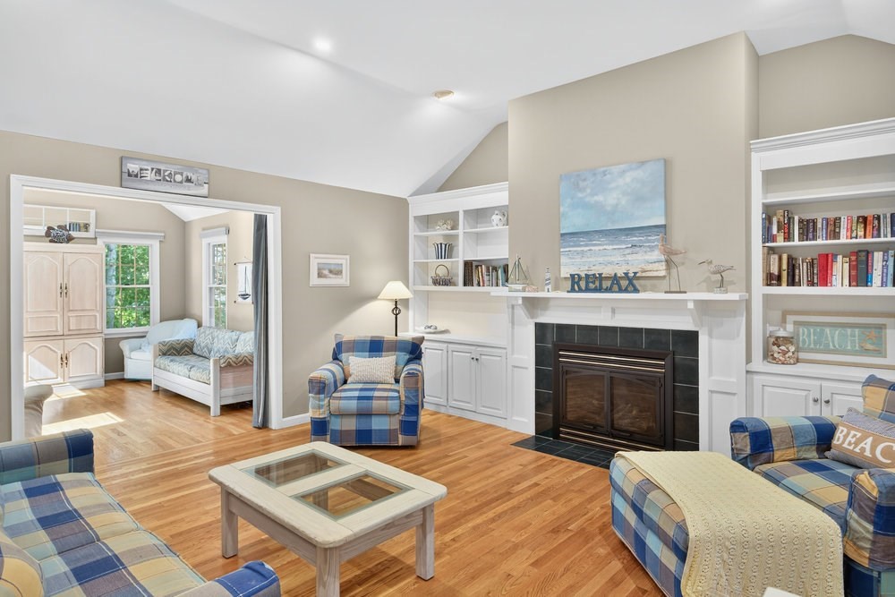 3 Stephen Hopkins Road Harwich, MA 02645 - Photo 8 of 42 a living room with furniture a fireplace and a book shelf
