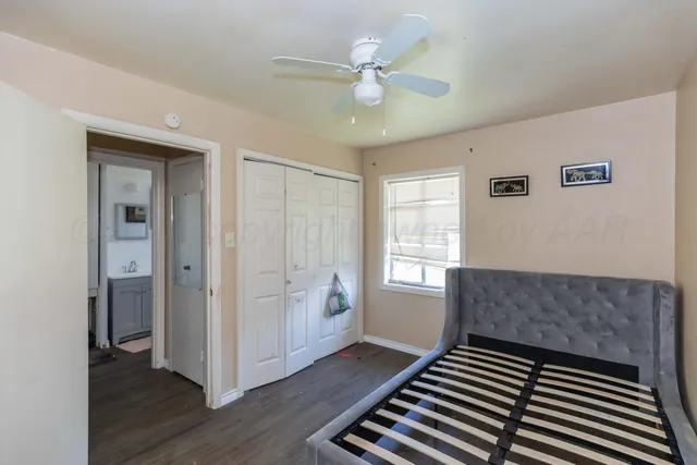 a living room with a bed and wooden floor