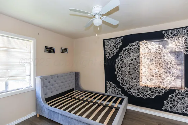 a view of a livingroom with wooden floor and a ceiling fan