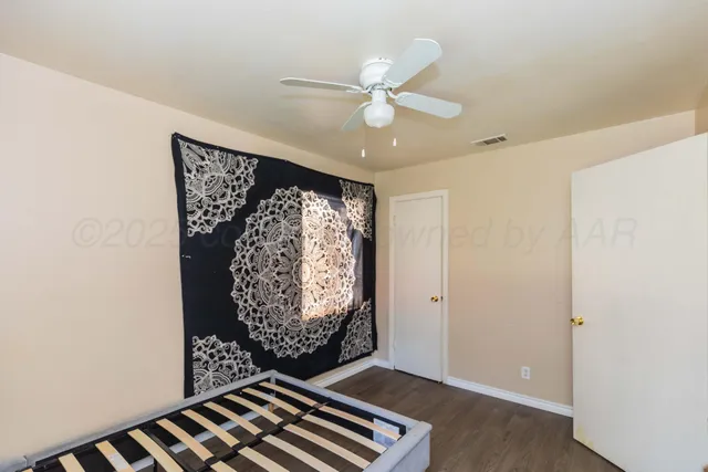 an empty room with windows and fan