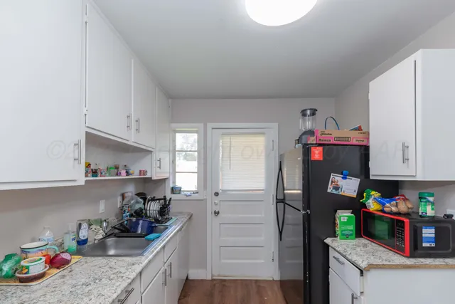 a kitchen with refrigerator and cabinets