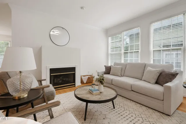 a living room with furniture a fireplace and a large window