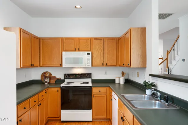 a kitchen with stainless steel appliances granite countertop a sink a stove and a refrigerator