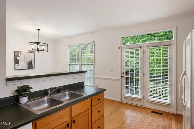 a kitchen with stainless steel appliances granite countertop a sink and a wooden floor