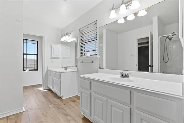 a spacious bathroom with a sink a mirror and a shower