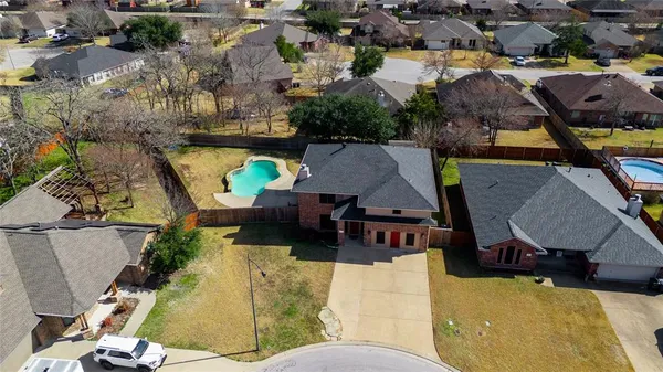 an aerial view of a house with swimming pool and outdoor seating