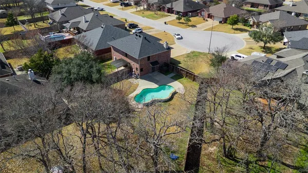 an aerial view of a house with a yard and trees