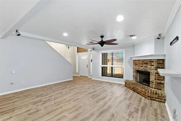 an empty room with fireplace wooden floor and windows